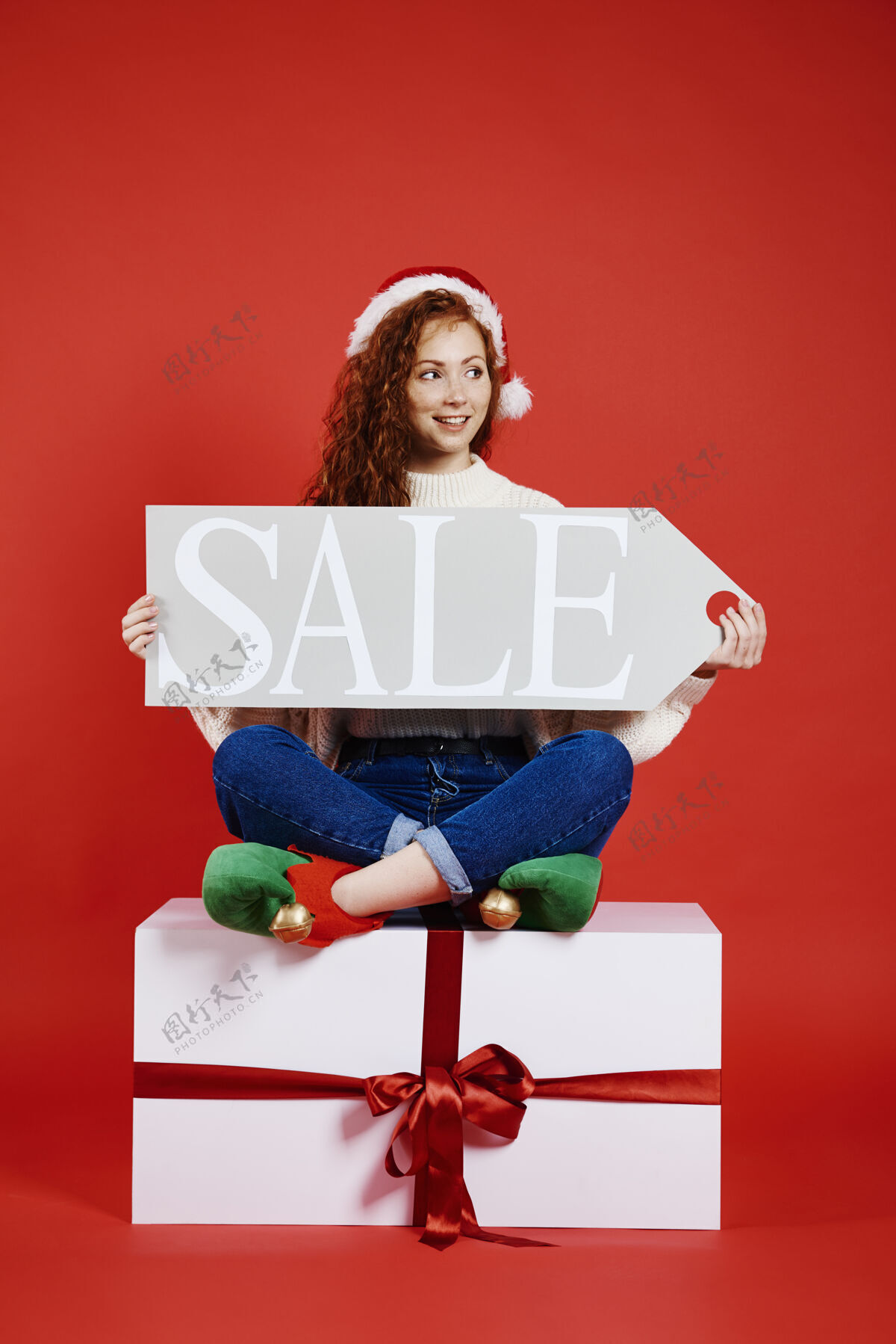 商店高举圣诞大甩卖旗帜的快乐女人在线购物消费主义礼物