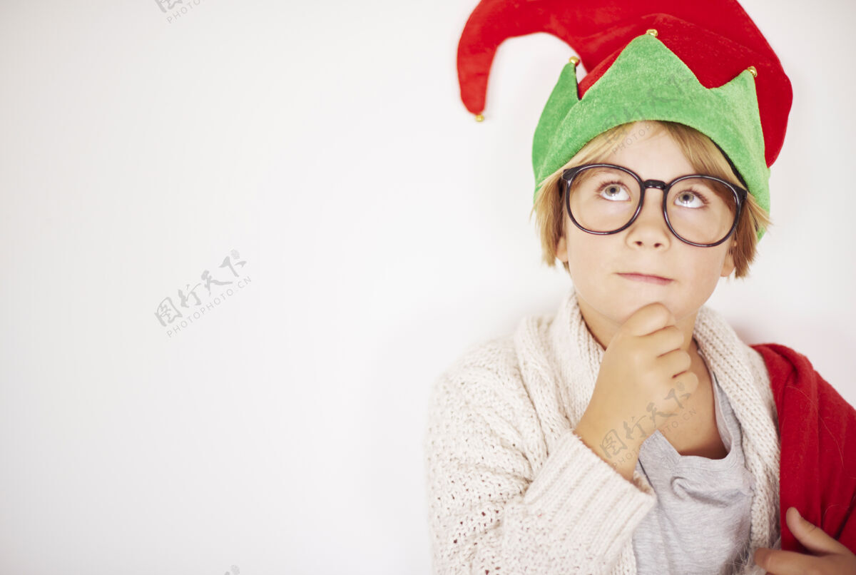 圣诞礼物墙前体贴的小精灵微笑做梦帽子