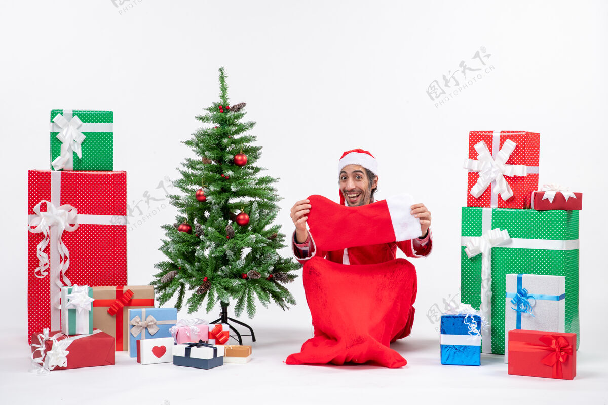 礼物圣诞老人带着礼物盒和圣诞树坐在那里沉思近圣诞老人坐