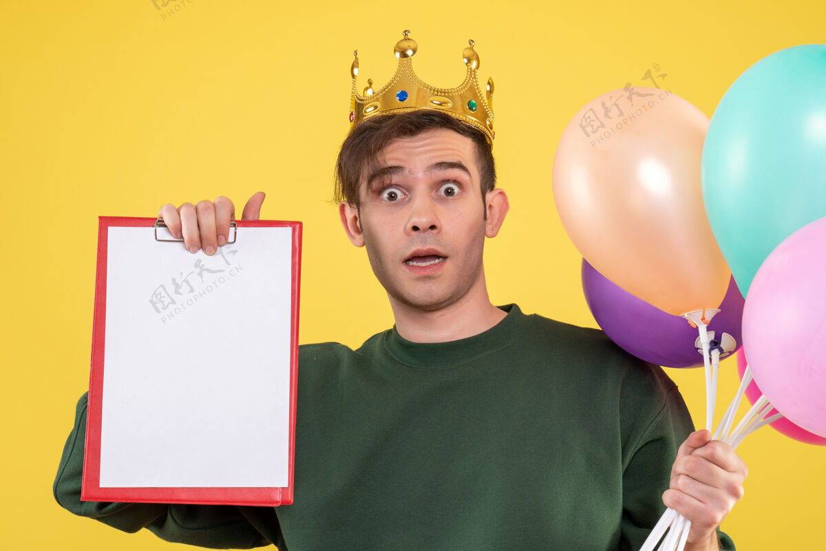 庆祝正面图：戴着皇冠的年轻人拿着黄色的气球惊奇孩子人