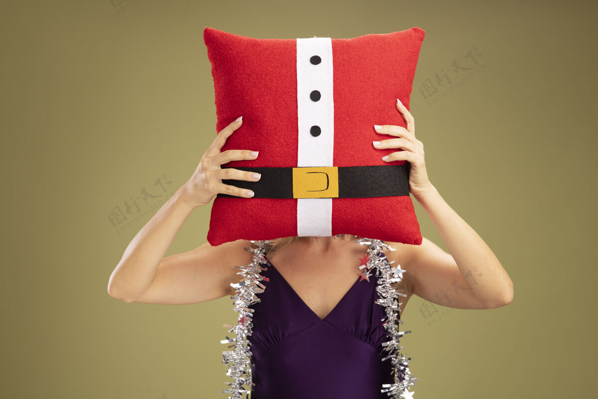 穿年轻漂亮的女孩穿着紫色的裙子 脖子上戴着花环 脸上戴着花环 橄榄绿的墙上还隔着一个圣诞枕头枕头年轻圣诞节