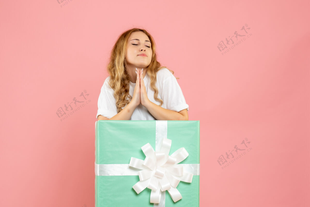 情感蓝色礼品盒内的年轻女性正面图蓝色年轻女性丝带
