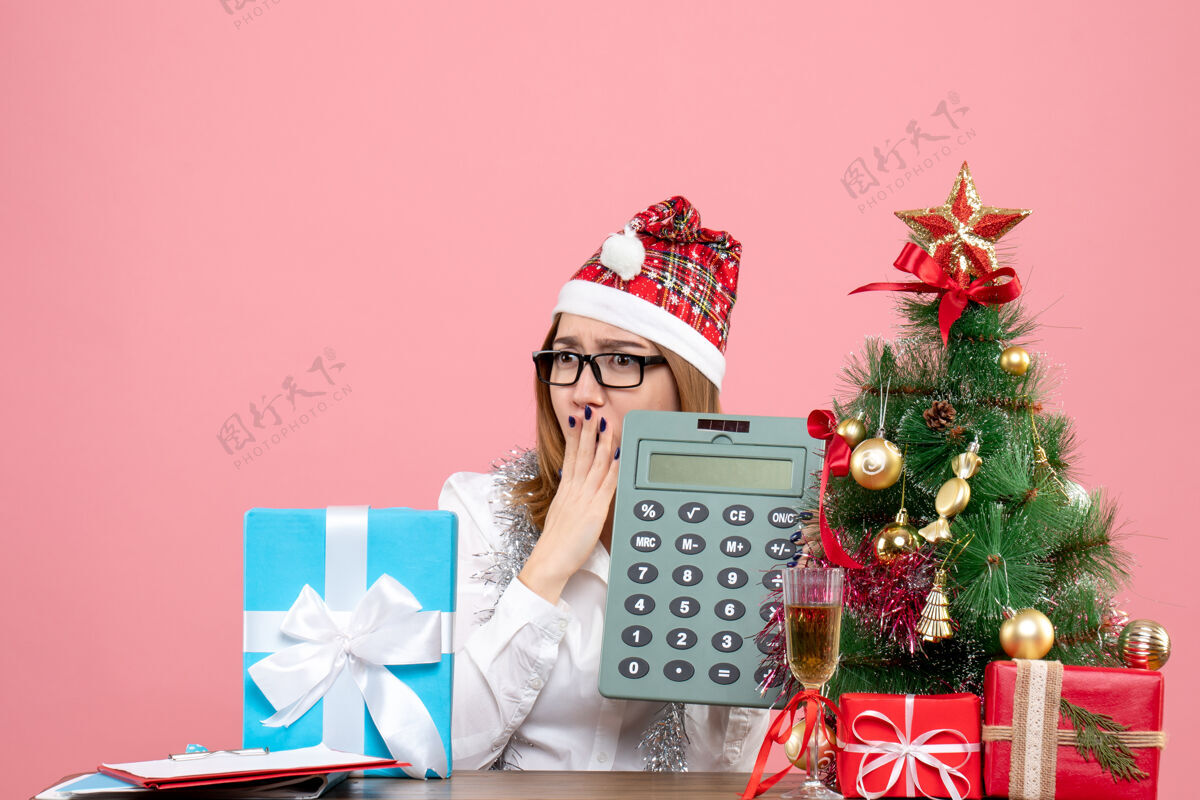 礼物女工手持计算器围着粉色礼物的正视图键盘乐器礼物盒子