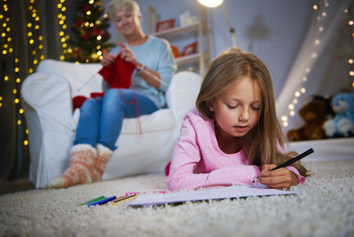 圣诞老人躺在前面画画的女孩圣诞老人圣诞夜手写