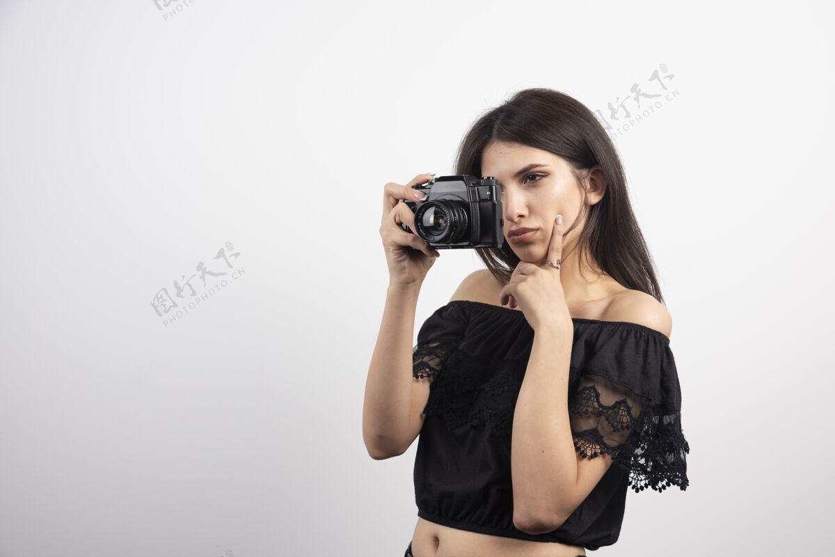 年轻黑发女人用相机拍照焦点持有相机