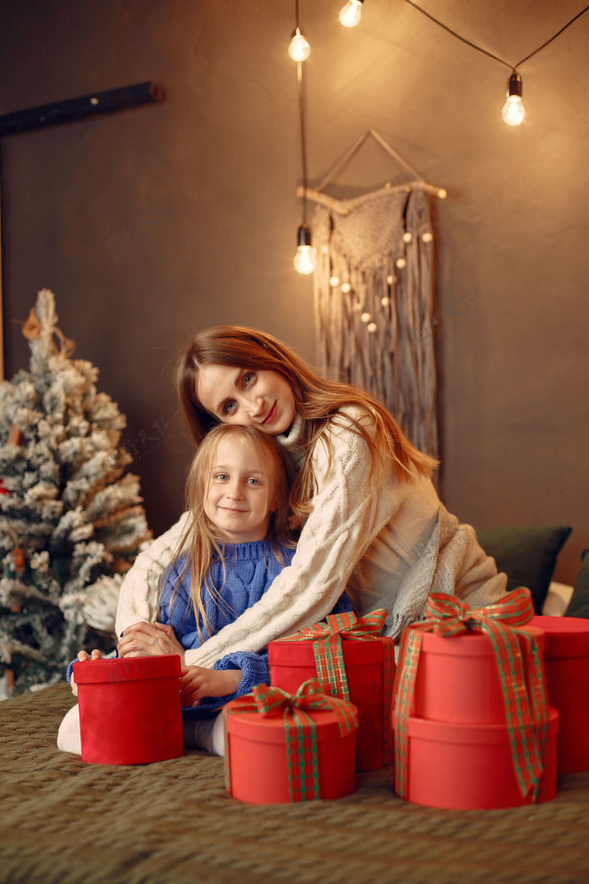 绿色人们在为圣诞节做准备母亲在和女儿玩耍一家人在节日的房间里休息孩子穿着蓝色毛衣碗礼物花环