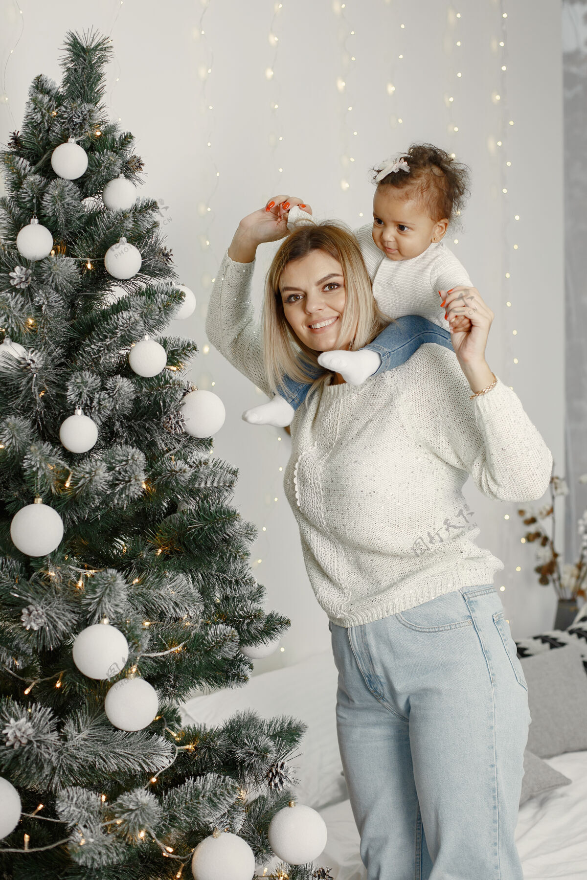 毛衣人们在为圣诞节做准备母亲在和女儿玩耍一家人在节日的房间里休息孩子穿着毛衣花环小国际