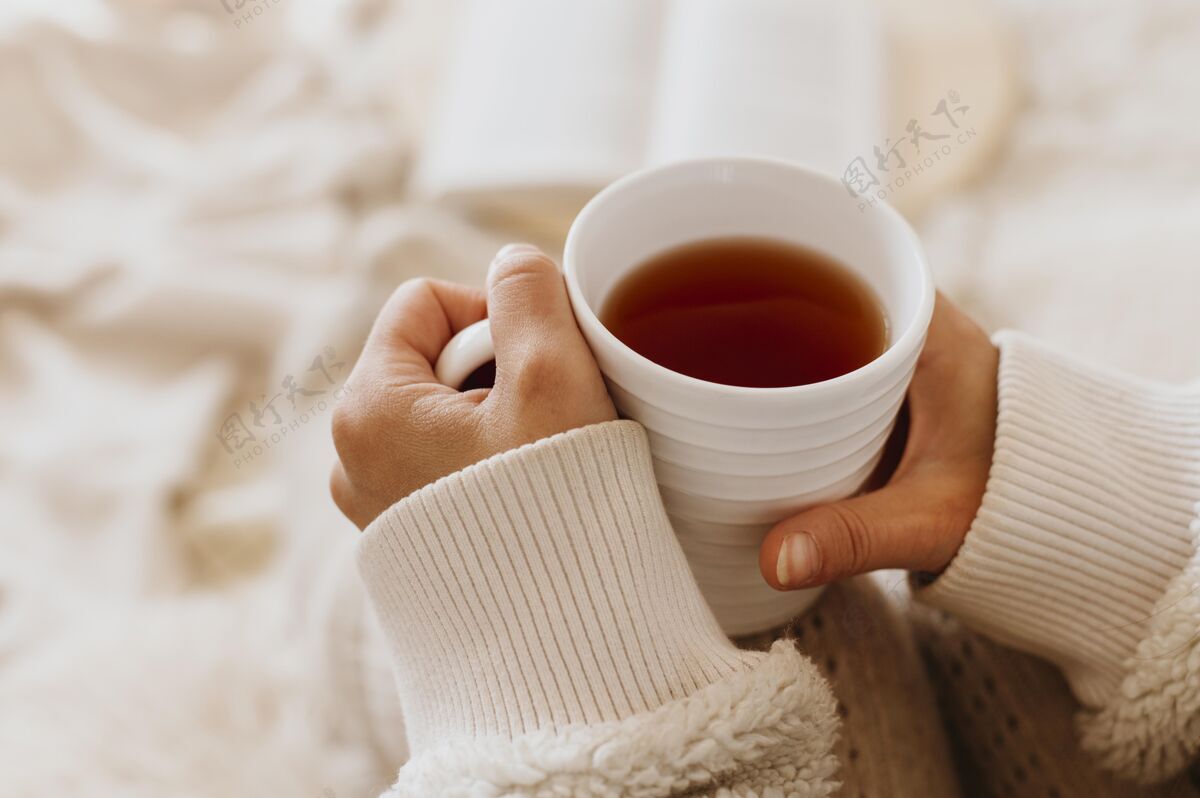 季节年轻女子一边喝茶一边享受寒假季节性冬天舒适