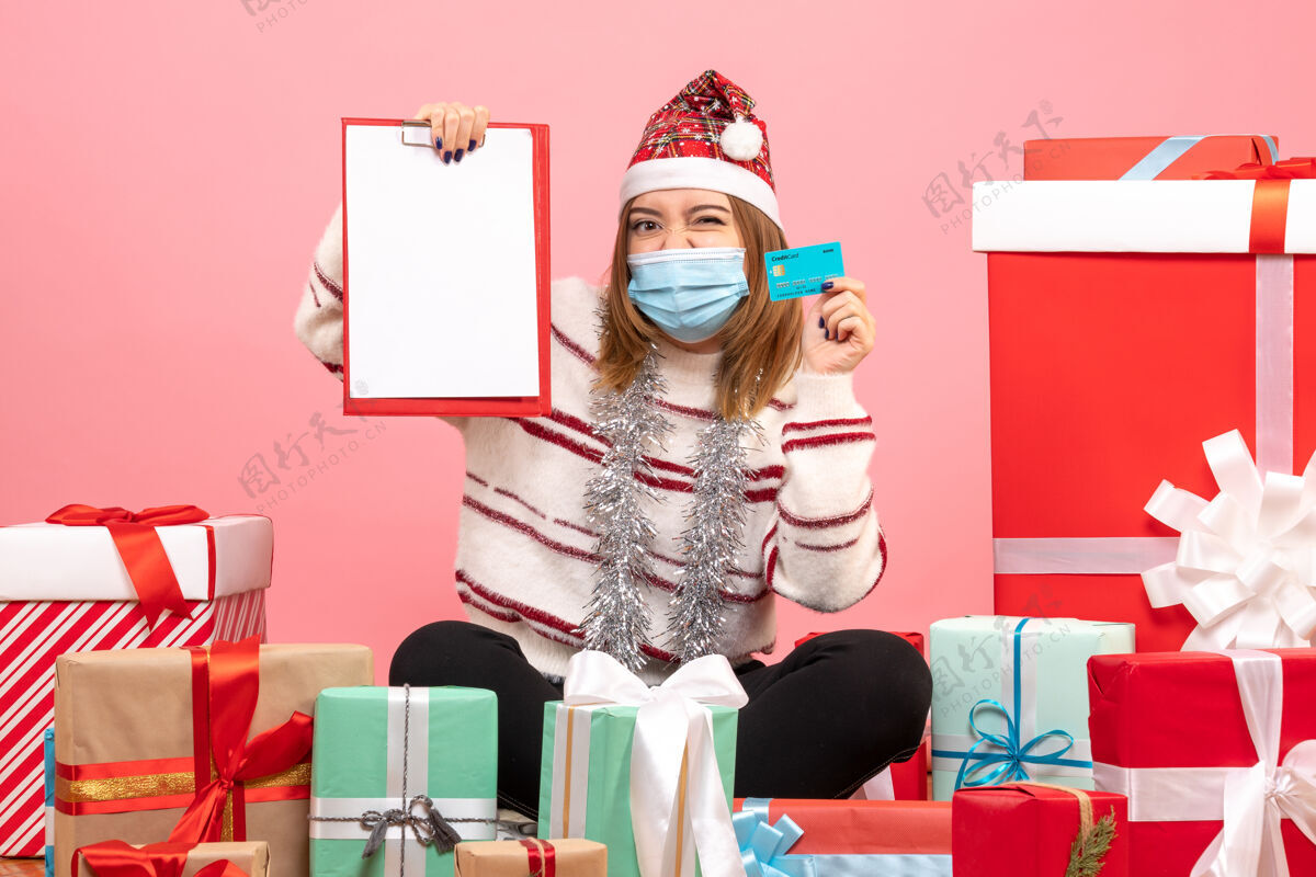 流行性疾病正面图年轻女性围坐在礼物旁边帽子圣诞节Covid