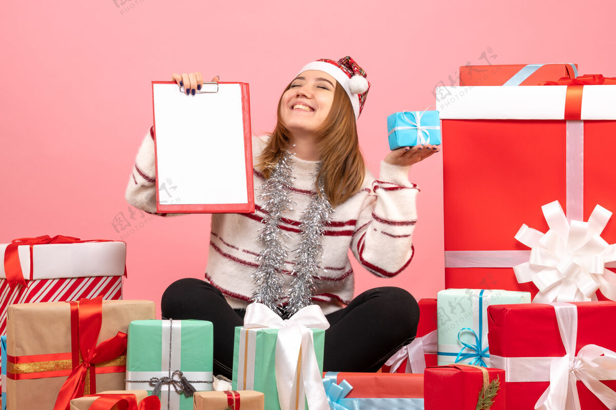 礼物前视图年轻女性围坐在圣诞节礼物与文件说明年轻女性漂亮节日
