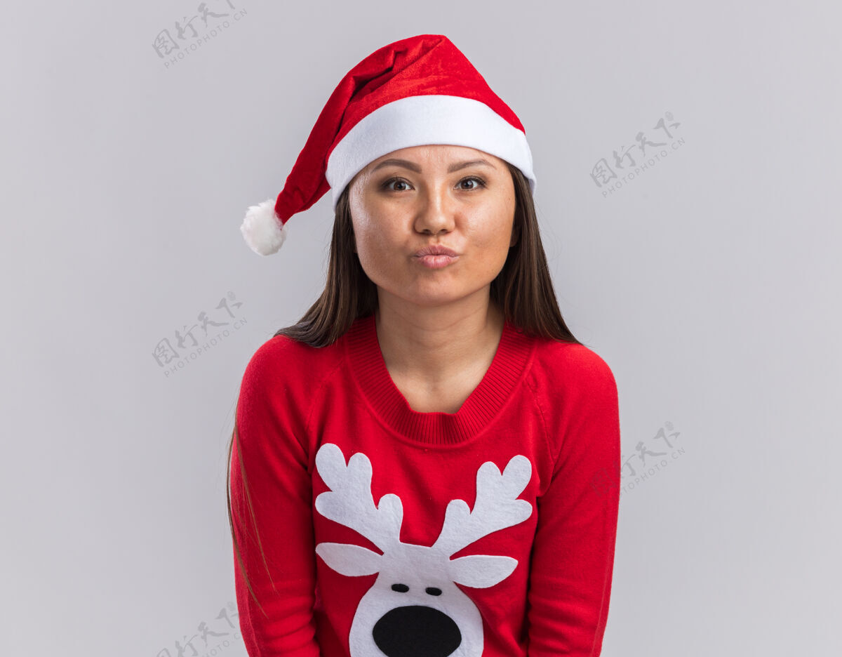手势年轻的亚洲女孩戴着圣诞帽 穿着毛衣 在白色的背景上显示亲吻的手势毛衣高兴帽子