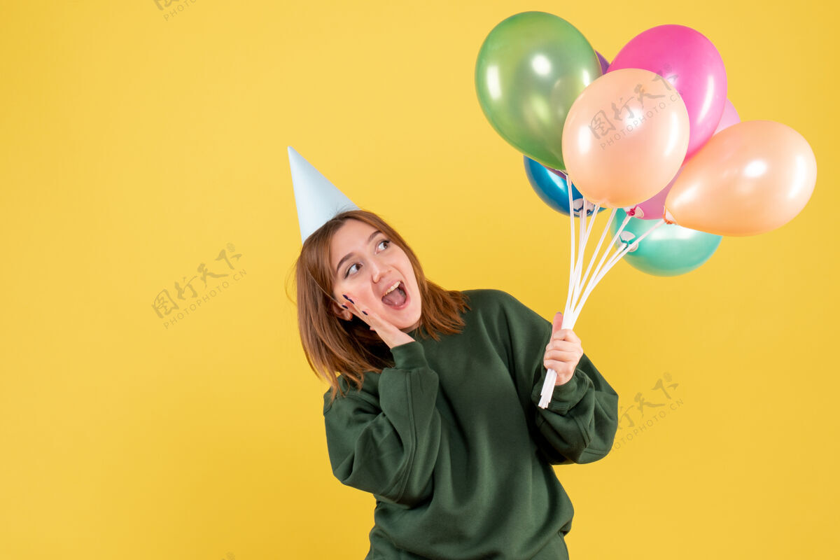 女性正面图：带着彩色气球的年轻女性节日圣诞节女人