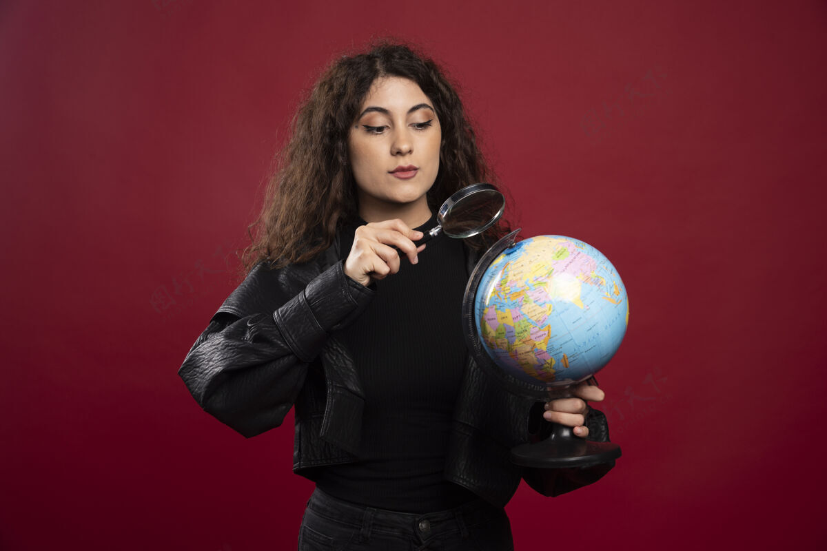 模型一个穿着全黑衣服的年轻女人拿着一个地球仪地图时尚肖像