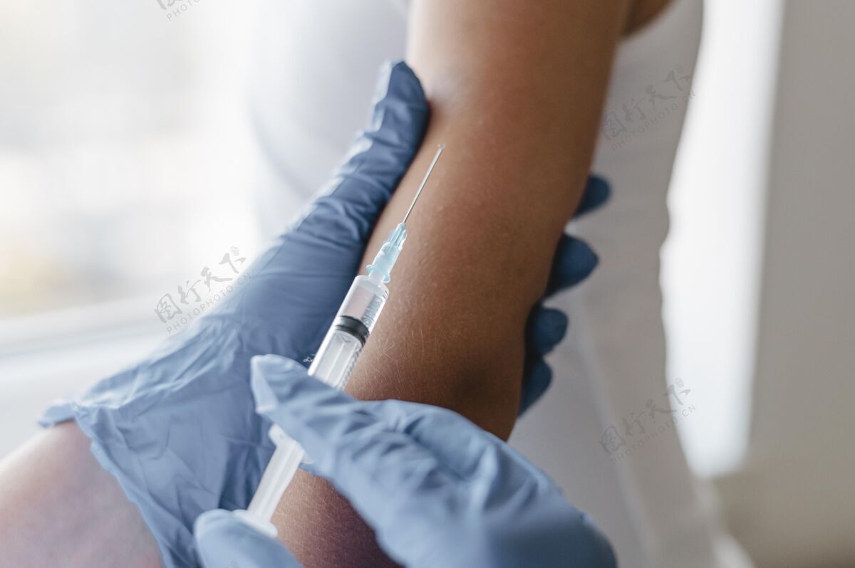 注射器戴手套的医生给孩子打疫苗水平医生疫苗