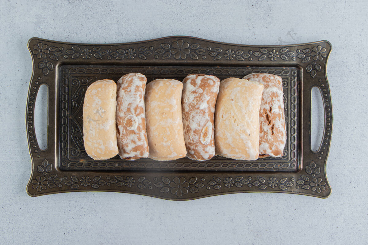 烘焙食品饼干包装在大理石背景上华丽的托盘上美味美味饼干