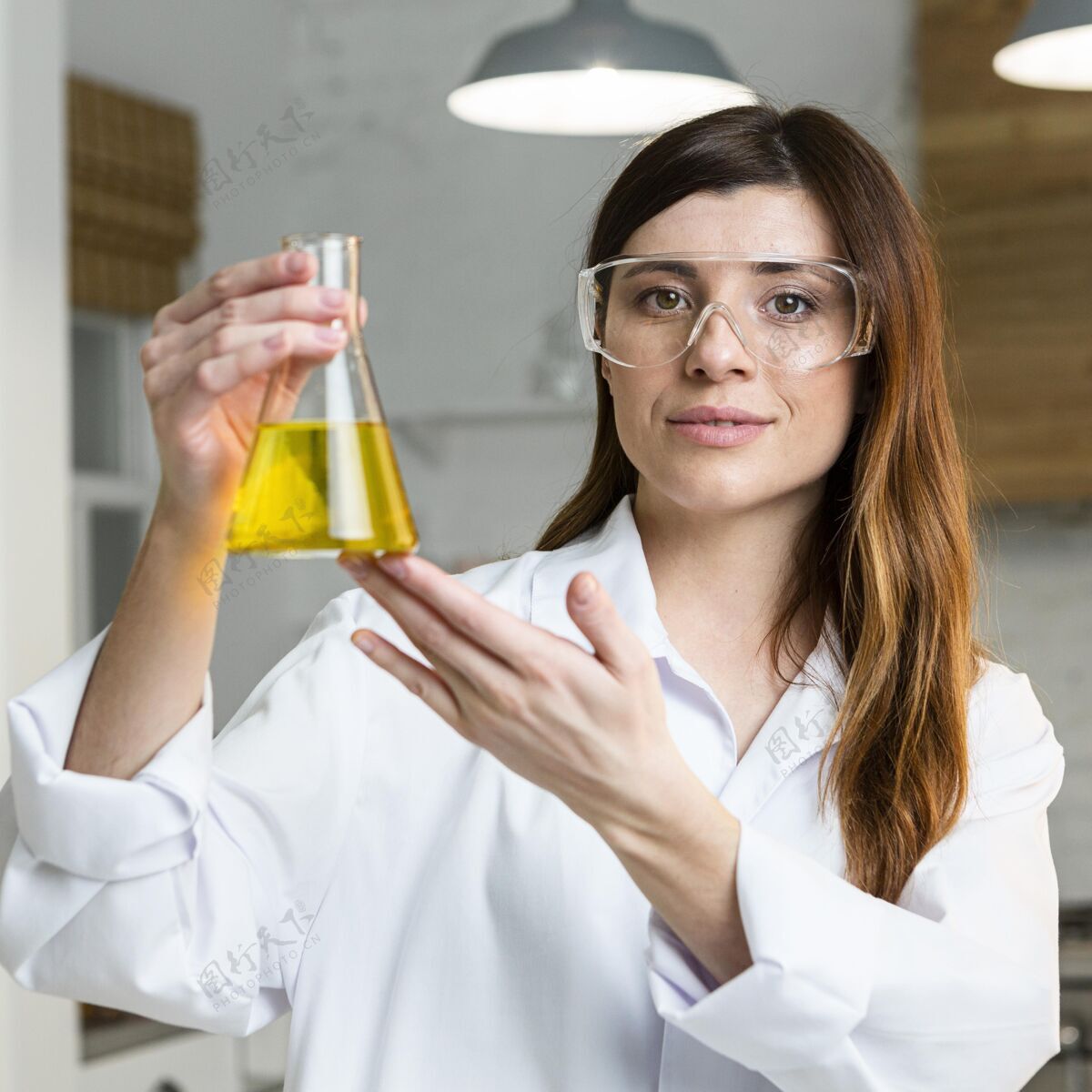 女性戴着安全眼镜拿着试管的女科学家的正视图测试科学炼金术