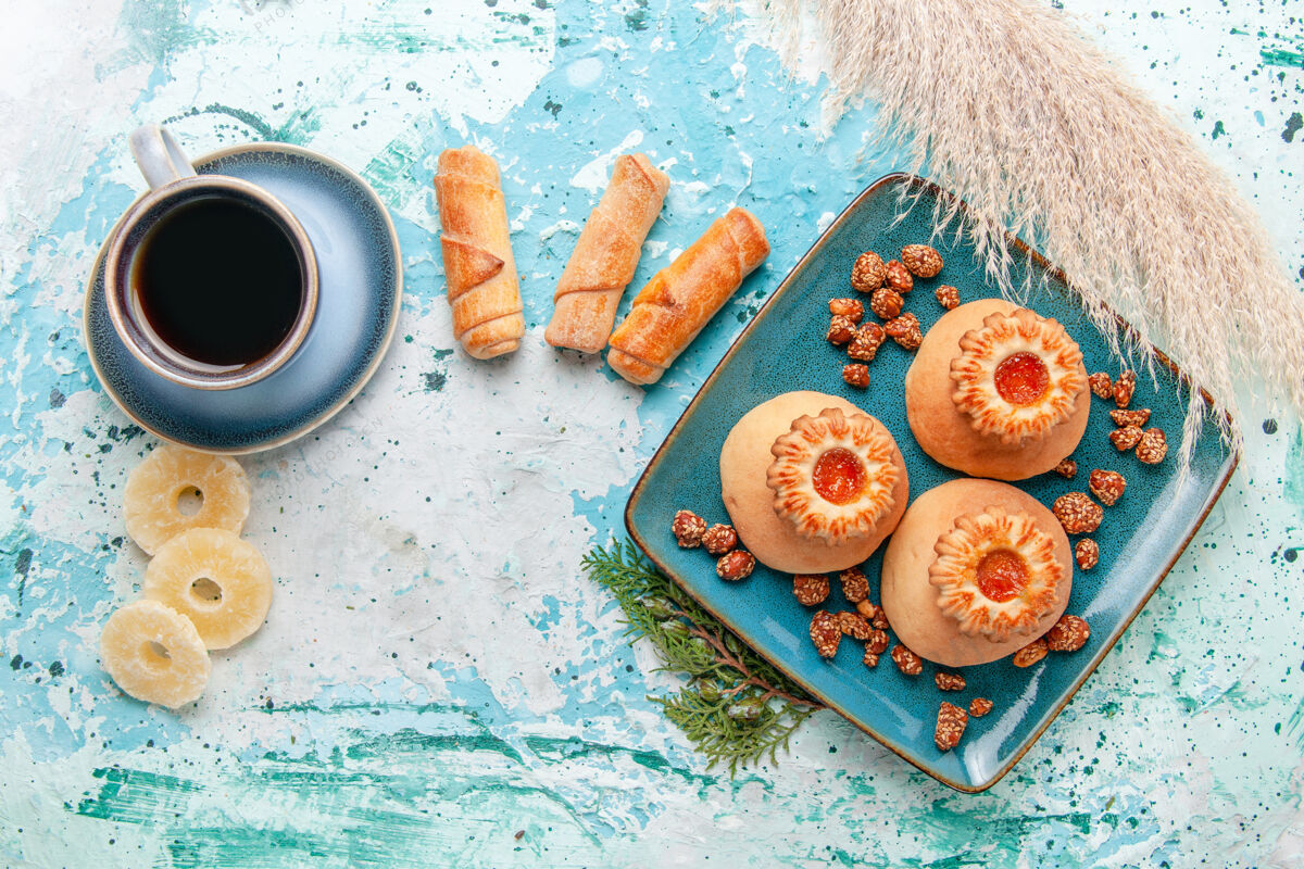 生的俯瞰美味的饼干与干菠萝环百吉饼和咖啡的蓝色表面饼干饼干甜甜的糖的颜色颜色饼干晚餐