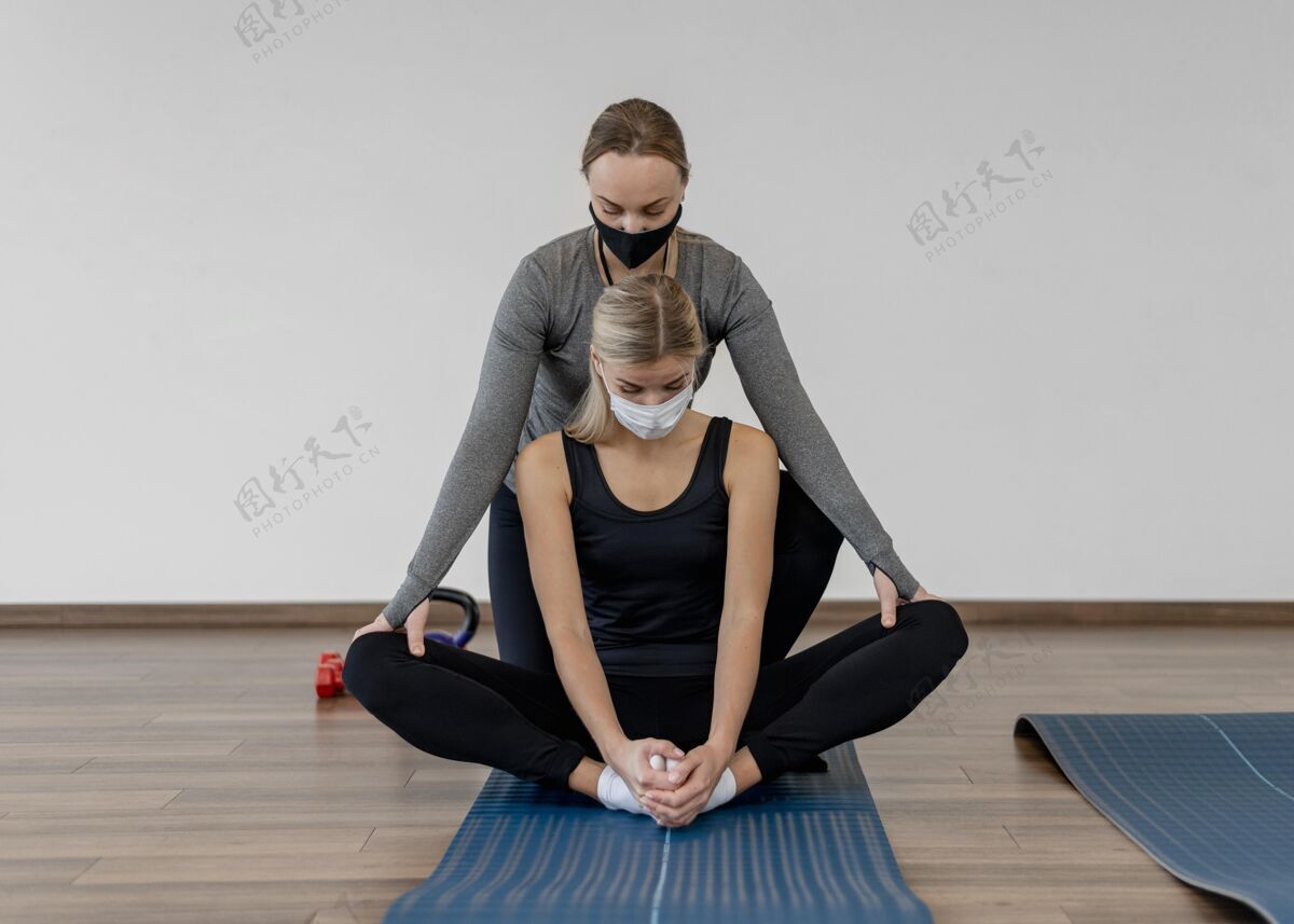 健身戴着医用口罩在健身房锻炼的年轻女子健康教练计划