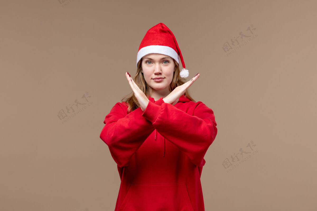 圣诞女孩前视图圣诞节女孩显示禁止标志棕色背景模型假日圣诞节标志帽子服装