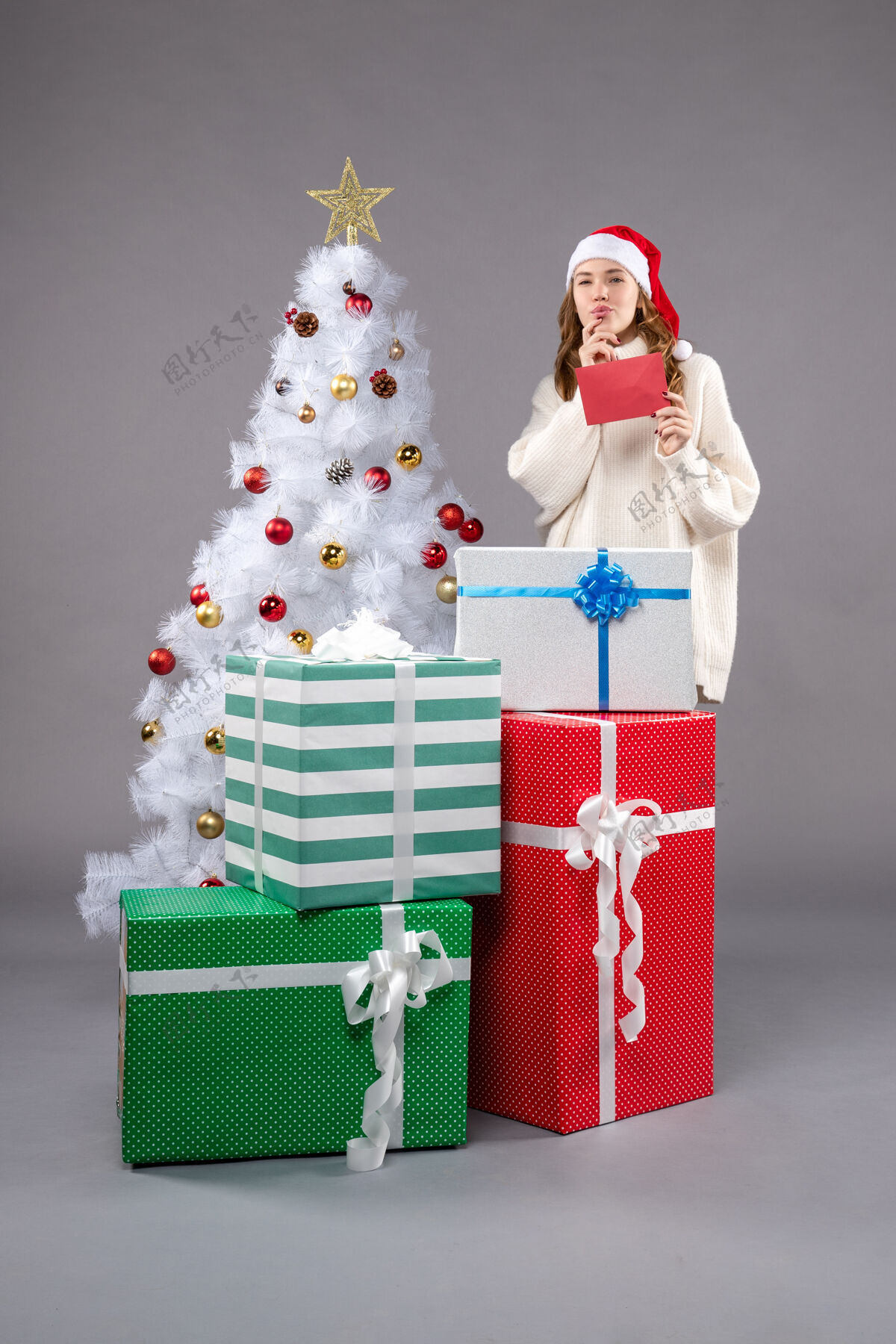 礼物拿着信封的年轻女人帽子圣诞圣诞树