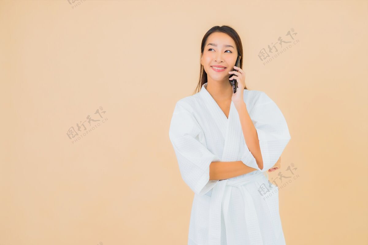 手机用米黄色智能手机描绘美丽的亚洲年轻女子休闲杯子手机