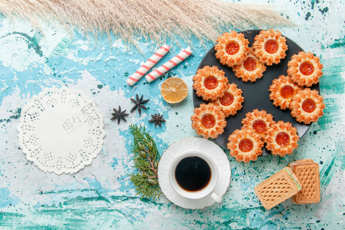 颜色俯瞰美味的小饼干与一杯咖啡和华夫饼上的蓝色办公桌饼干饼干甜甜的糖色茶茶饼干顶部