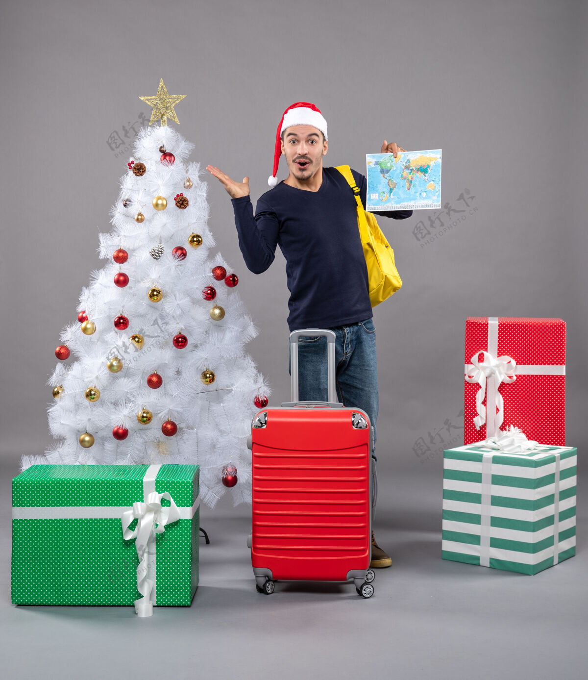 包带着背包的圣诞老人站在灰色的圣诞树旁 欣喜若狂庆祝圣诞树男人
