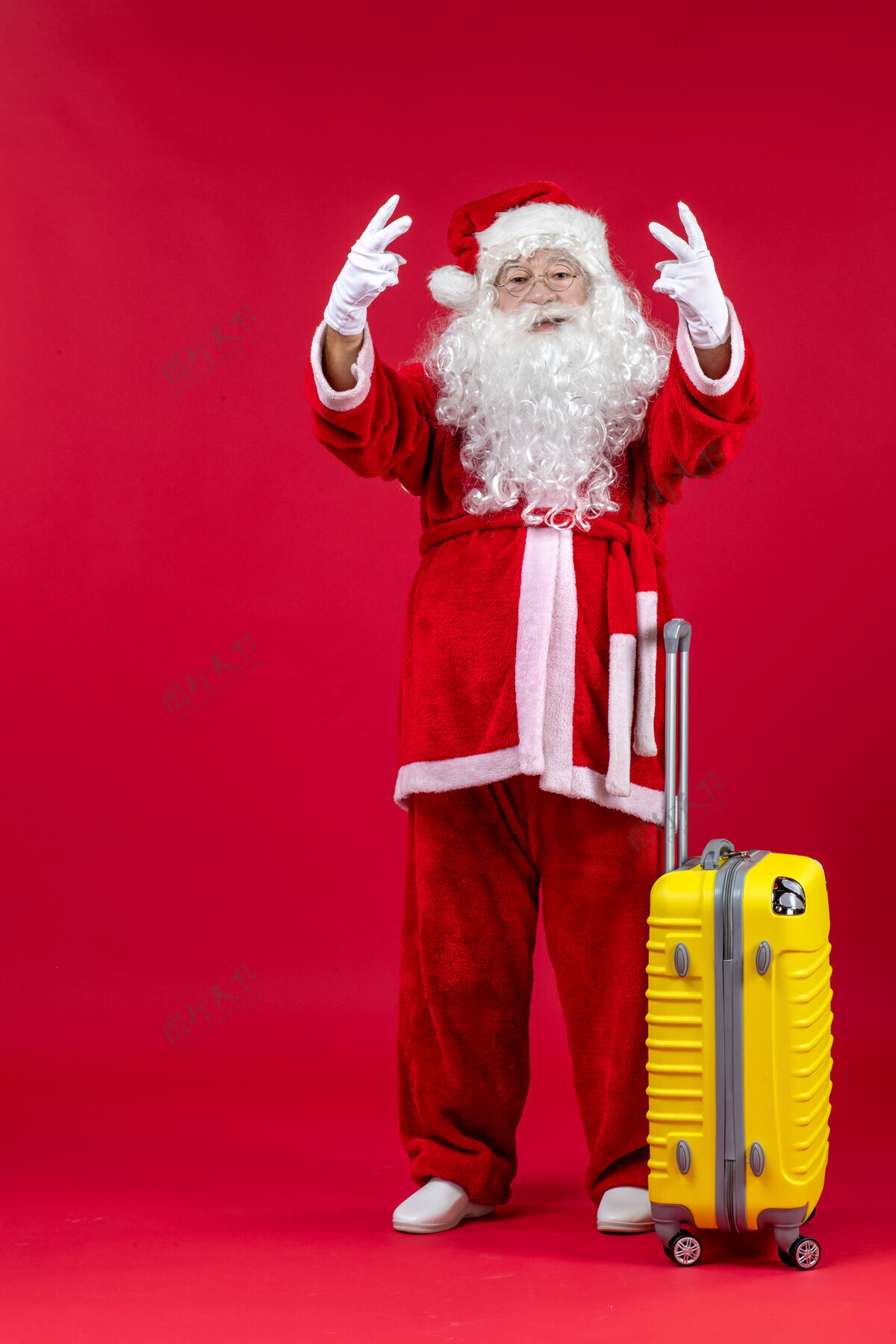 圣诞老人红墙上准备旅行的黄包圣诞老人的正视图圣诞老人男性假期