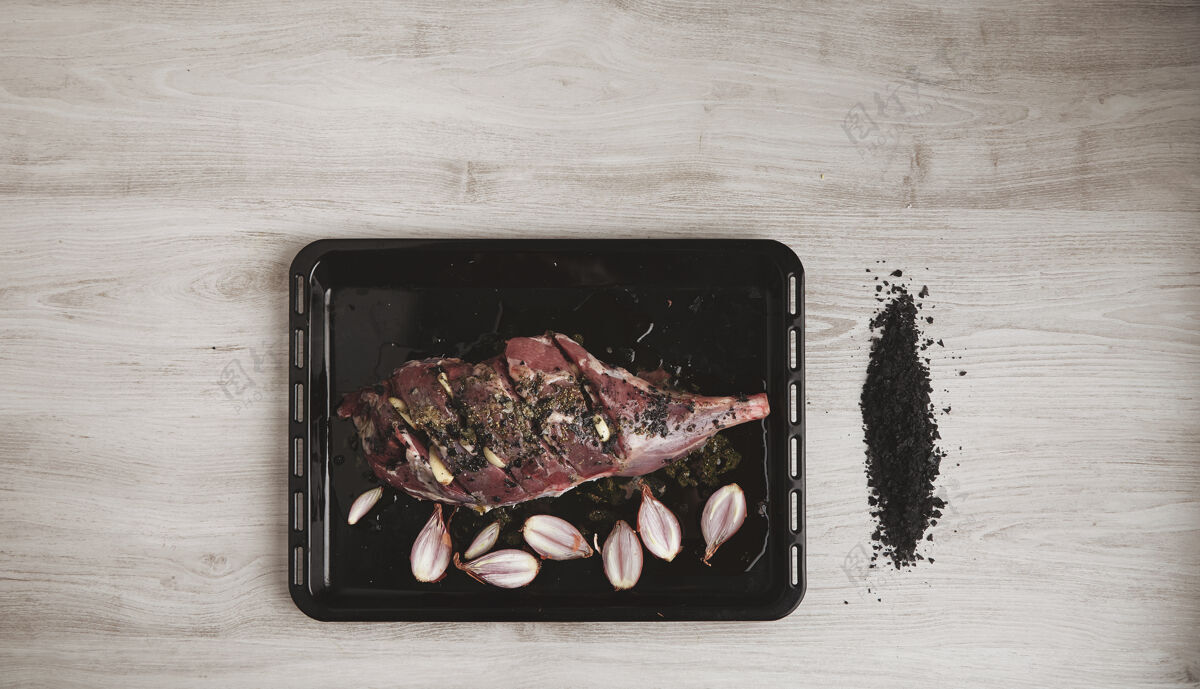 碗预煮的冰岛羊腿肉 配香料 香草和小洋葱 放在黑色烤盘上 旁边放着磨碎的火山黑盐 俯视图 隔离在白色木桌上橄榄盐木材