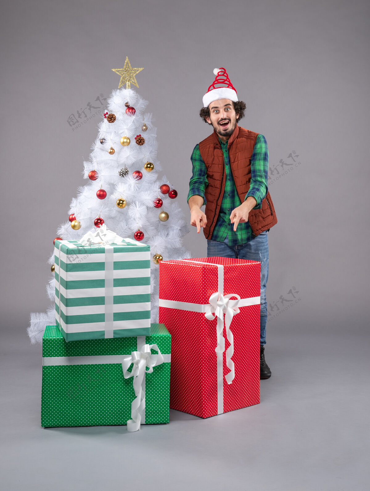 购物年轻的男性在灰色的圣诞礼物周围灰色帽子礼物