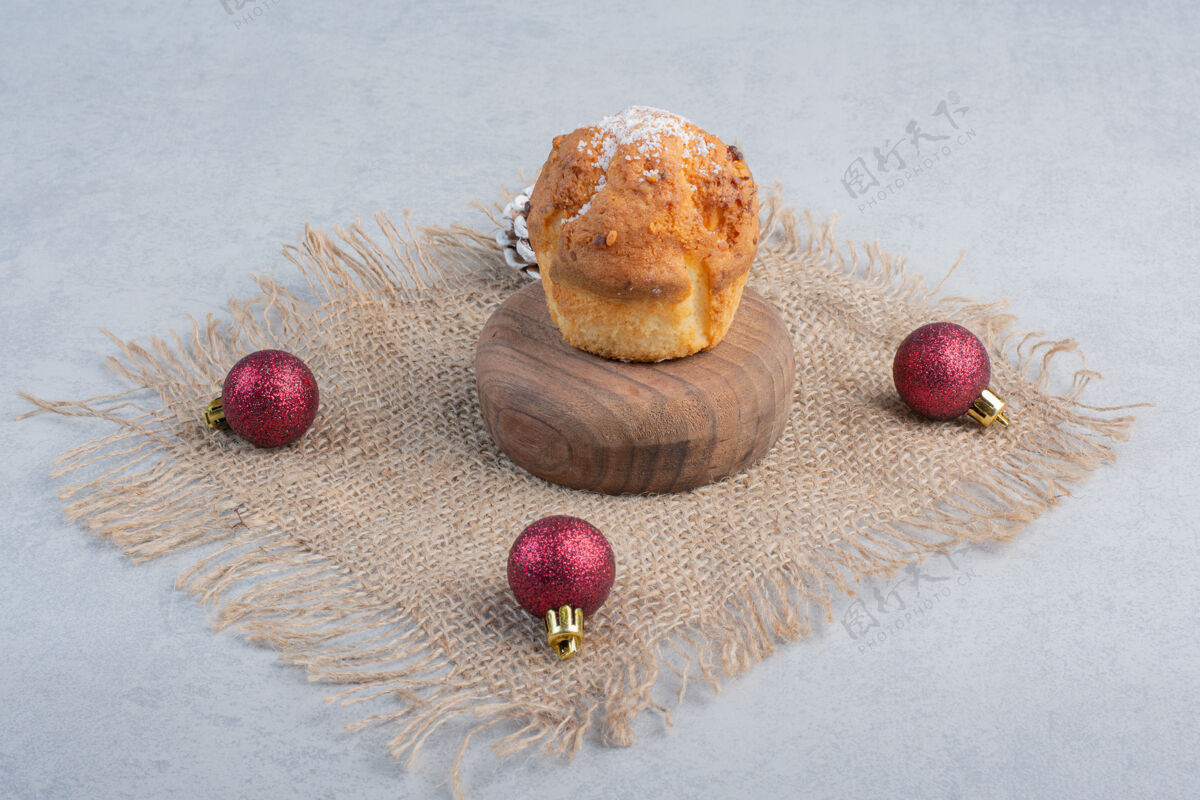 糖果在大理石表面的一块布上放一个纸杯蛋糕和圣诞装饰品纸杯蛋糕松木装饰