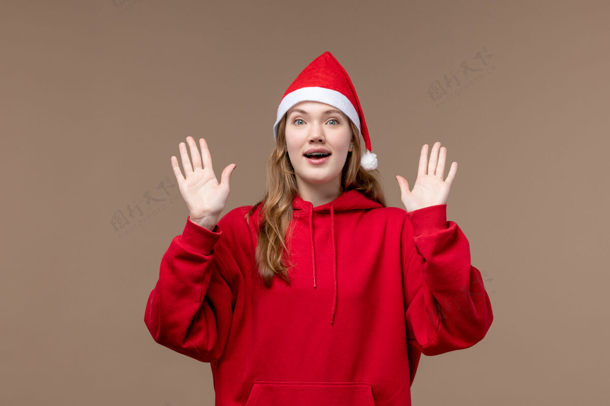 人们正面图：年轻女性 穿着棕色背景的圣诞斗篷 感慨圣诞假期背景圣诞节帽子