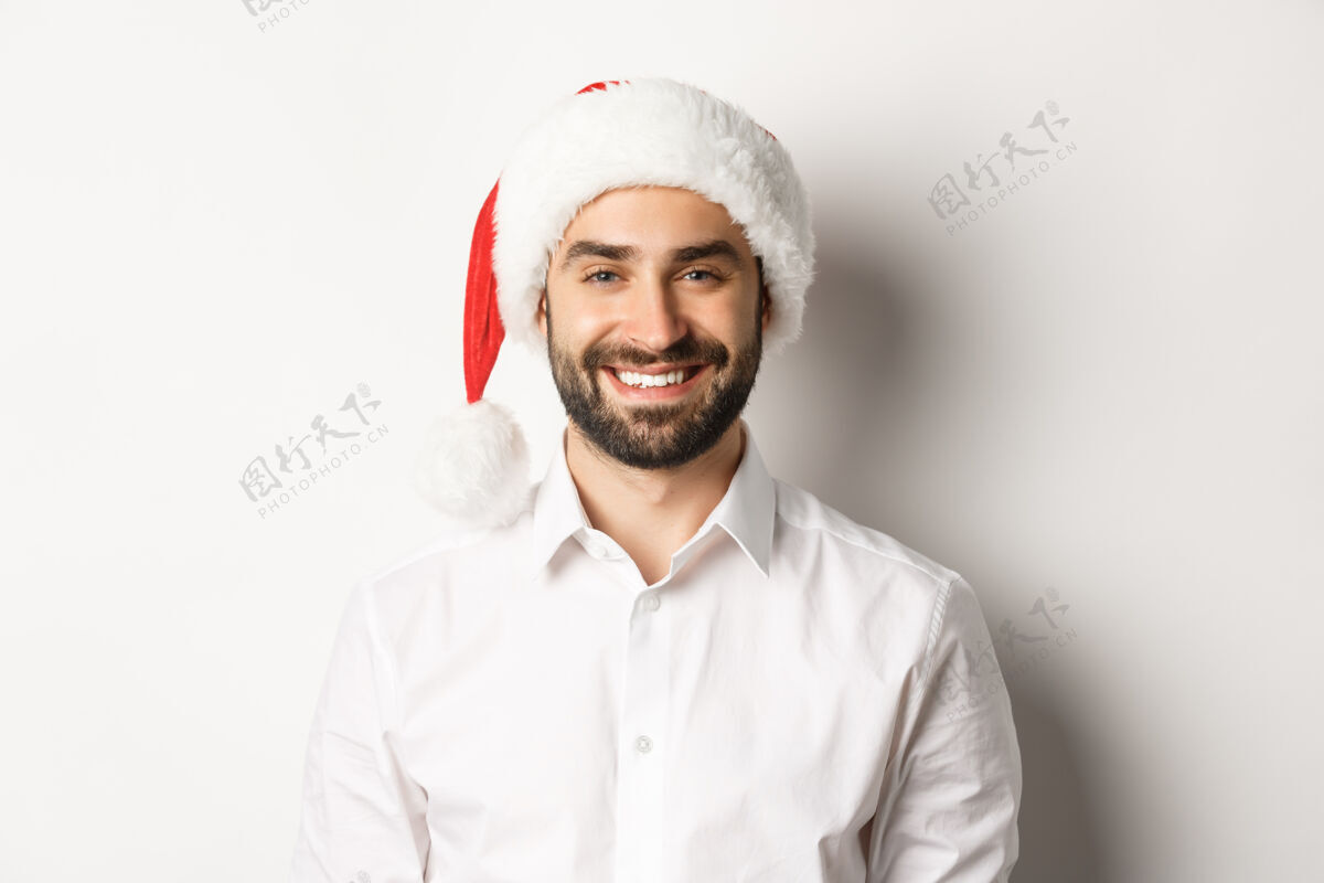 微笑特写镜头：快乐的大胡子男人庆祝圣诞节 戴着圣诞派对帽 微笑着 站着快乐开朗帽子