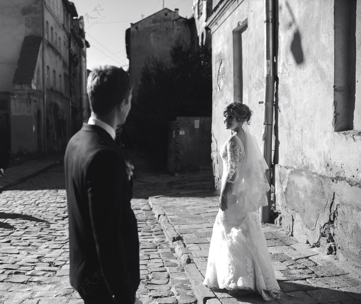 婚姻新郎新娘在老城的街道上摆姿势新郎新娘可爱