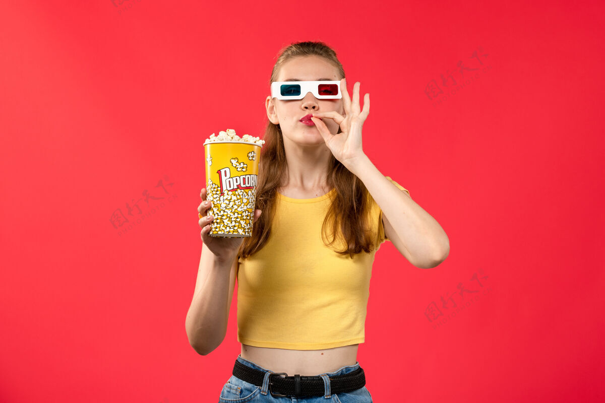 爆米花前视图年轻女性在电影院拿着爆米花包在红墙电影院的d太阳镜有趣的电影电影院电影电影
