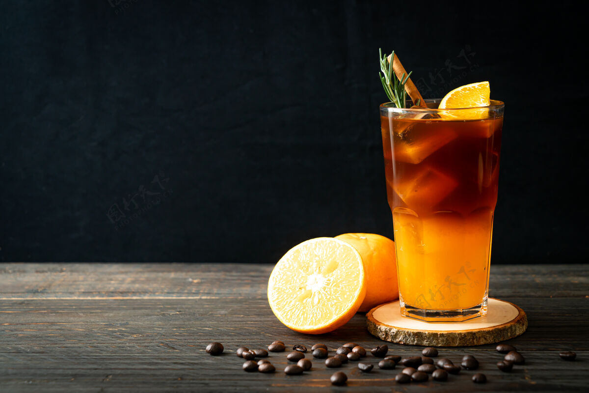 咖啡杯一杯冰美式黑咖啡和一层用迷迭香和肉桂装饰的橙汁和柠檬汁美式咖啡美味浓缩咖啡