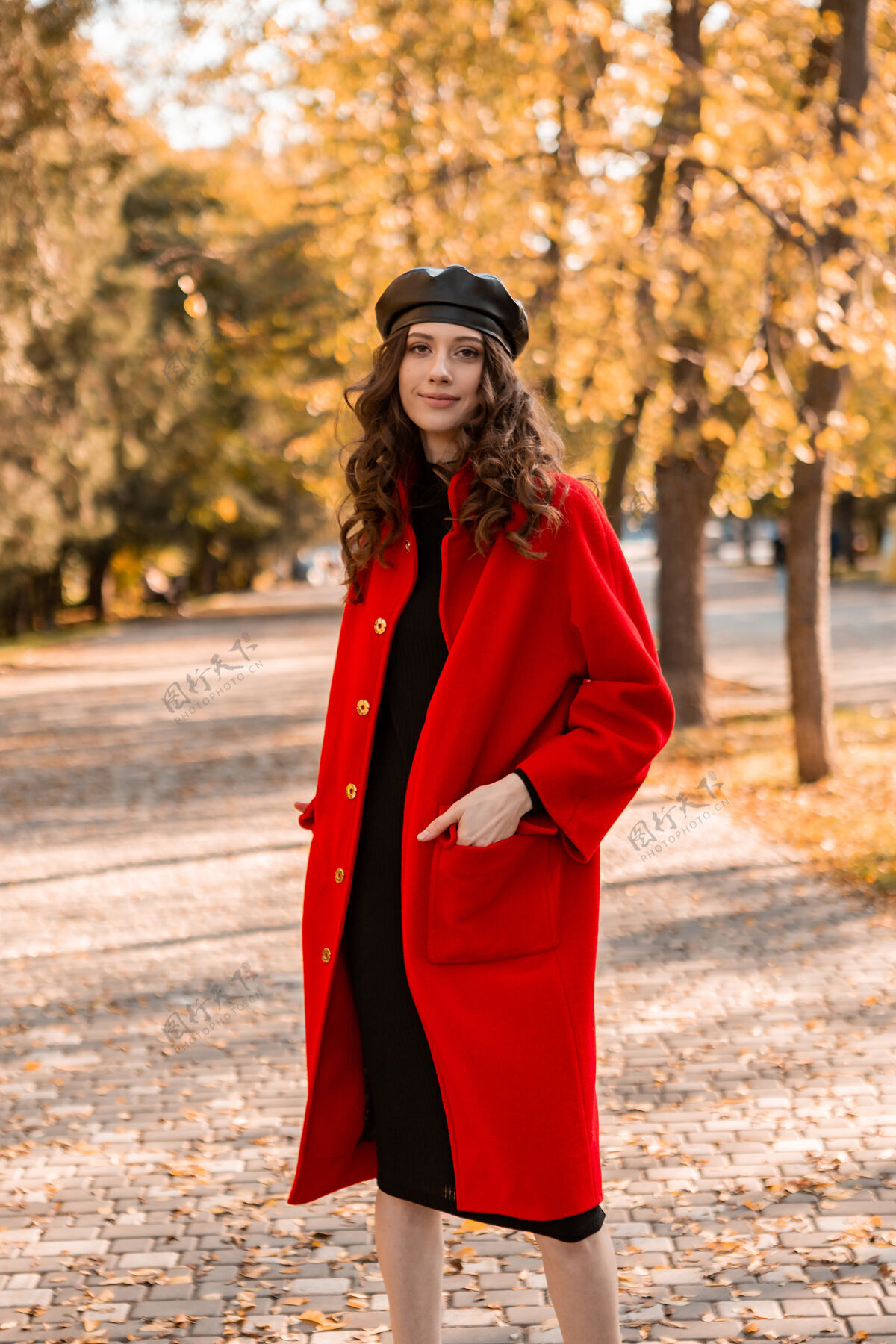 外套迷人的时尚微笑的女人卷发漫步在公园穿着温暖的红色外套秋季时尚 街头风格 戴贝雷帽穿着户外漂亮
