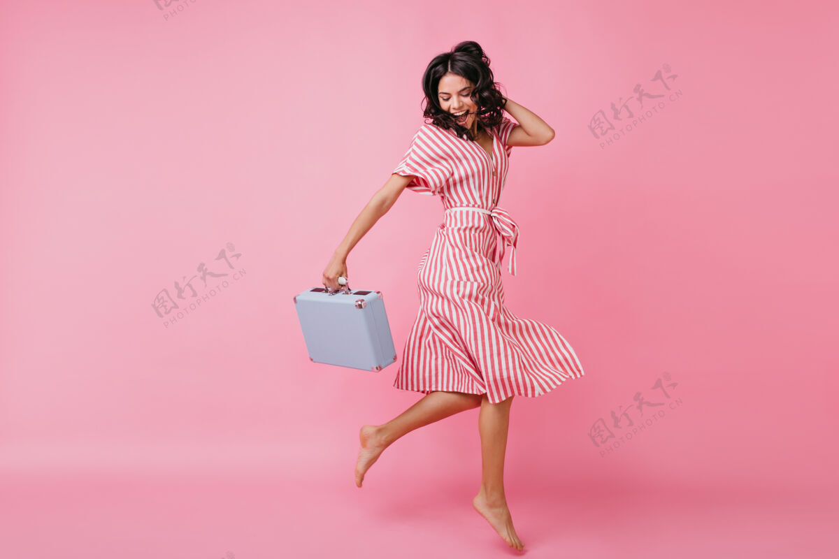 粉色意气风发的苗条女孩手里拿着包 一边玩乐一边跳舞身着裹身裙的意大利模特照可爱派对优雅