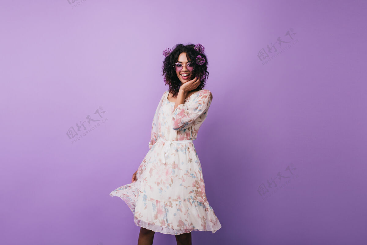 漂亮苗条的女孩 头上扎着蒜头 快乐地跳舞可爱的非洲年轻女子 穿着复古连衣裙摆姿势肖像女性紫色
