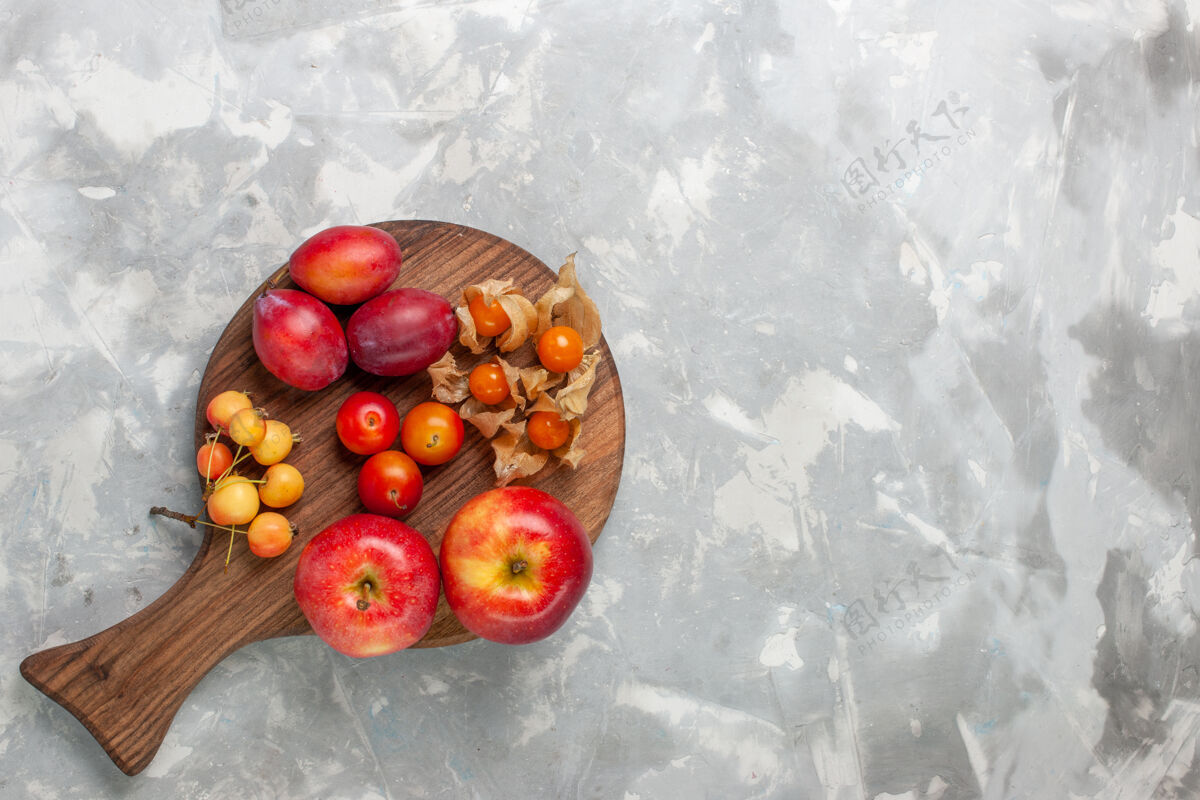 顶部顶视图不同形状的李子酸和新鲜水果与樱桃放在浅白的桌子上健康浆果新鲜