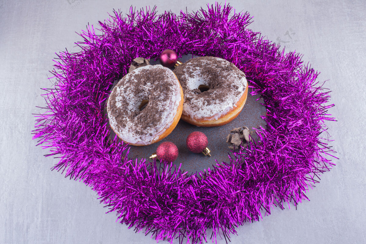 开胃在白色背景的木板上 紫色的花环环绕着光滑的甜甜圈装饰烘焙甜品