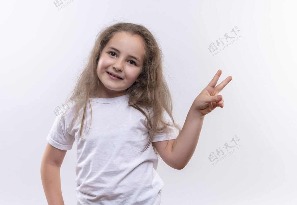 白色微笑的小女孩穿着白色t恤 在与世隔绝的白色背景下展示和平姿态T恤小展示