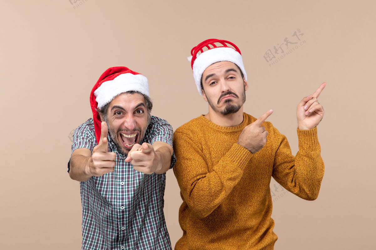 帽子正面图两个男人一个快乐一个悲伤 在孤立的背景上戴着圣诞帽圣诞老人男人男人