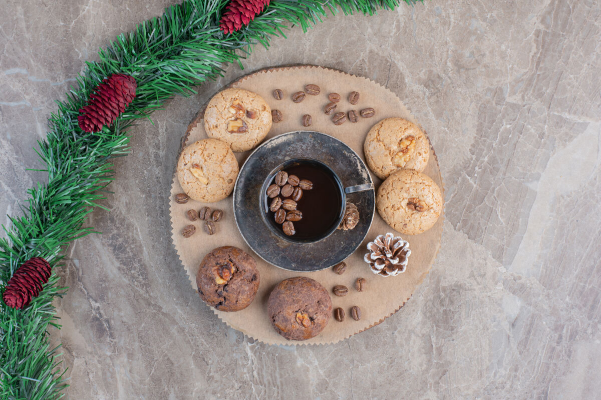 美味松果装饰花环旁边的一盘饼干和咖啡大理石松子花圈顶视图