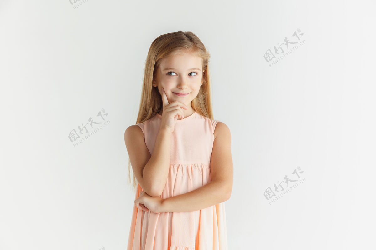 金发在白色摄影棚背景下 一个时尚的微笑着的小女孩穿着隔离的裙子摆姿势白人金发女模特人类的情感 面部表情 童年思考或梦想 活动自信套装