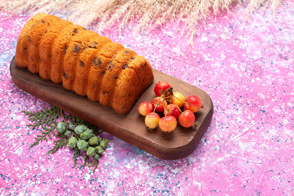 盘子正面是美味的蛋糕 甜美可口 粉红色的桌子上有甜樱桃饼干午餐面团