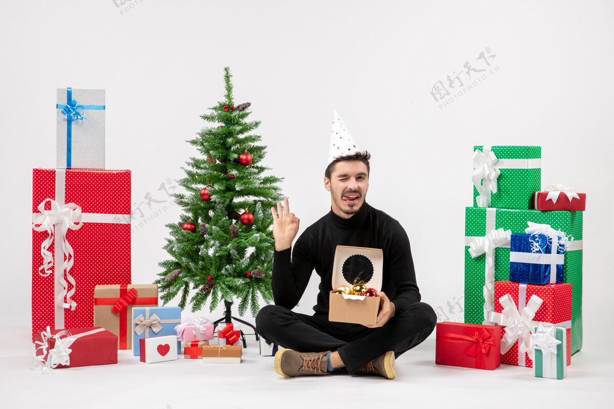 树年轻人围坐在白墙上的礼物面前快乐圣诞礼物
