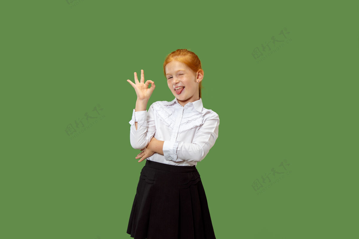 幸运快乐的少女站着 微笑着指着自己在时尚的绿色工作室背景孤立美丽的女性半身肖像人类的情感 面部表情的概念站立女学生十岁