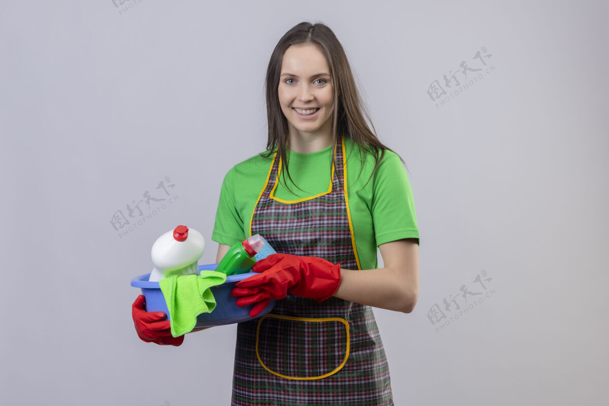 戴着微笑着打扫卫生的年轻女孩穿着制服 戴着红手套 拿着清洁工具 背景是孤立的白色拿着清洁白