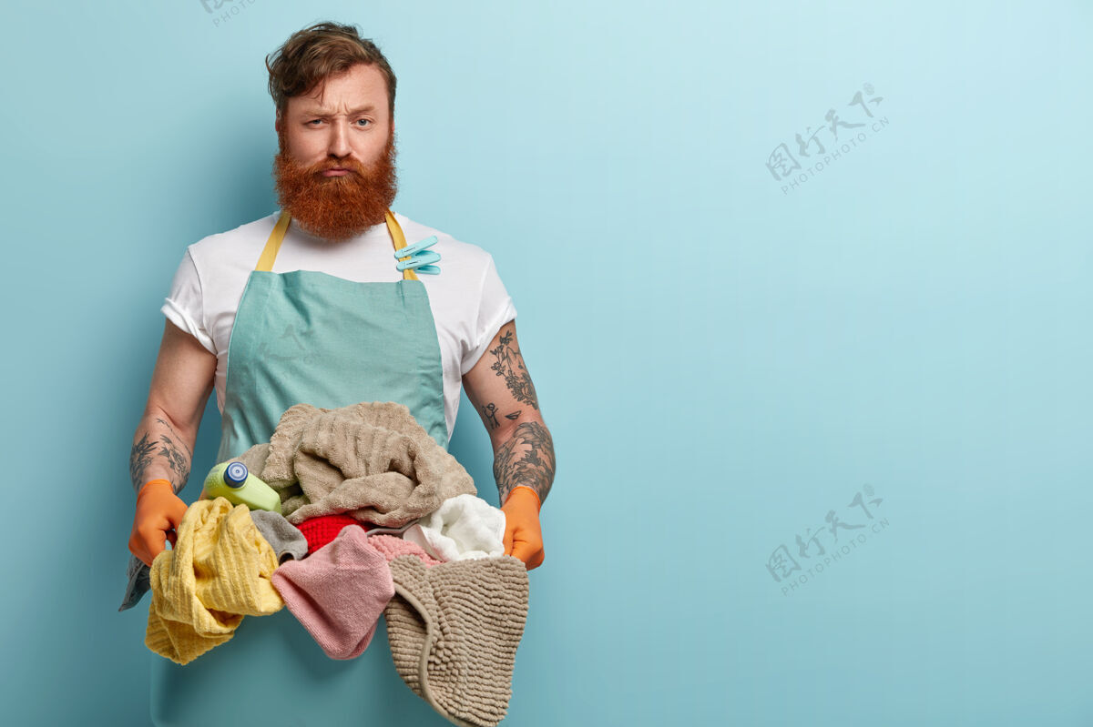 男忙碌不满的红发男子端着满满一盆洗好的衣服到洗衣机前 为辛苦的工作和家务而烦恼洗篮子纹身